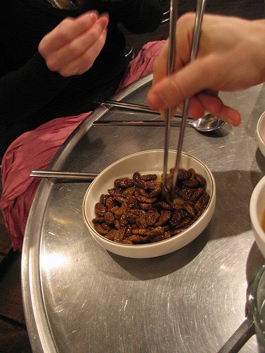Easting Bondeaggi with chopsticks in a restaurant