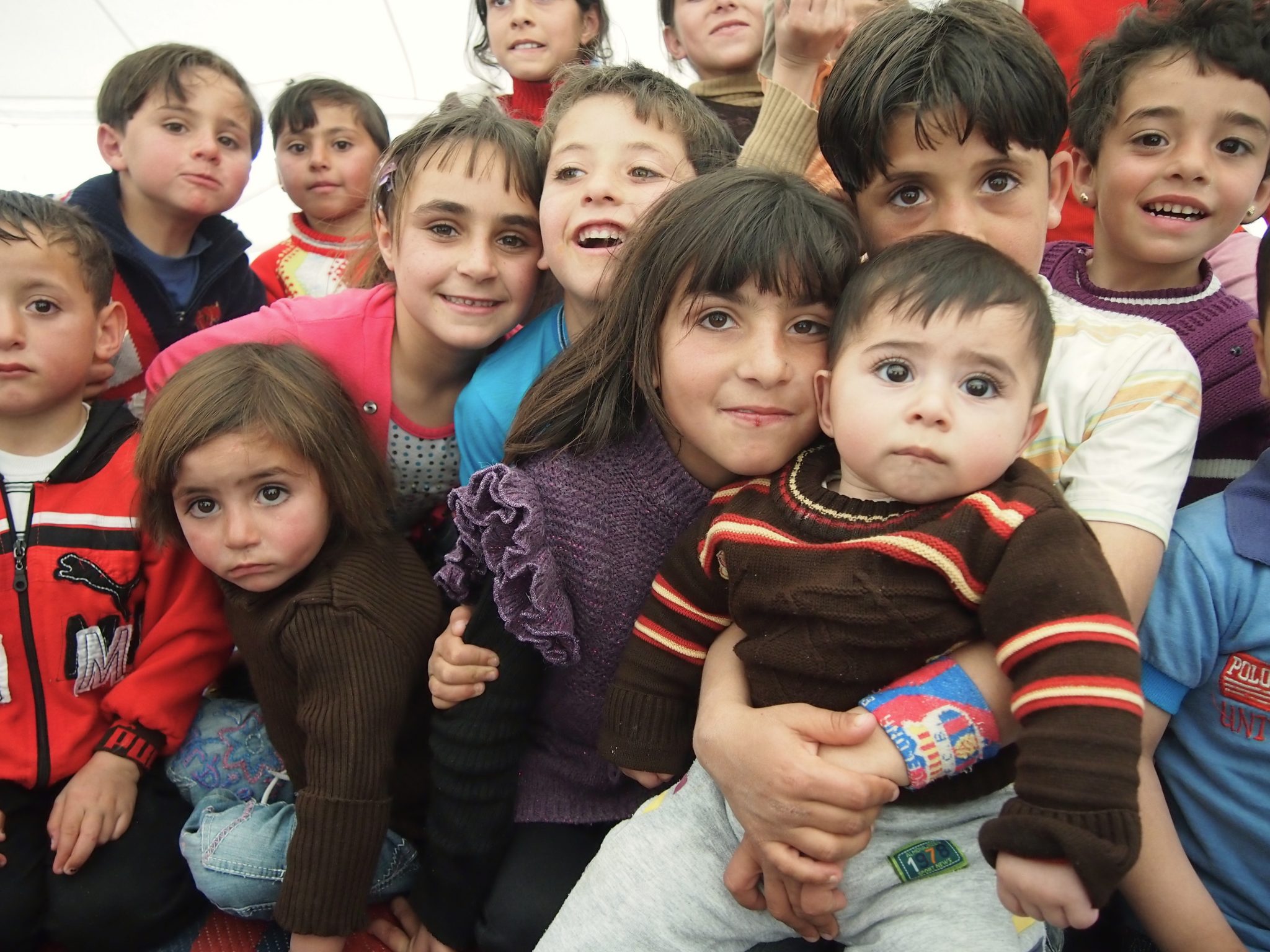 Children of Refugees smile for the camera.