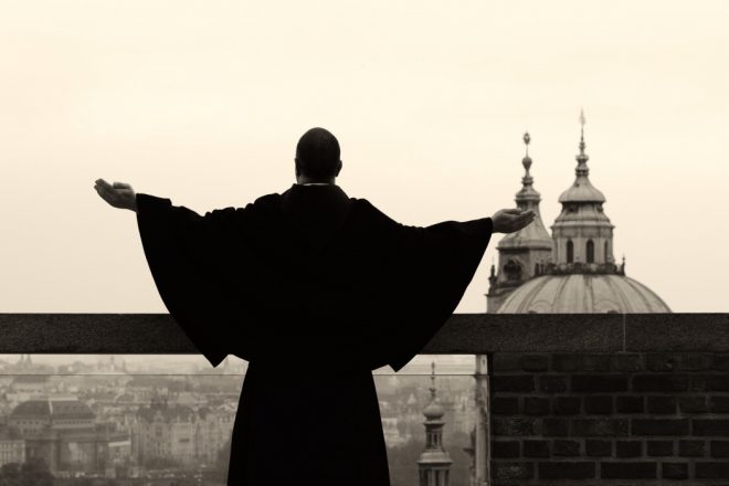 Monk raising his hands