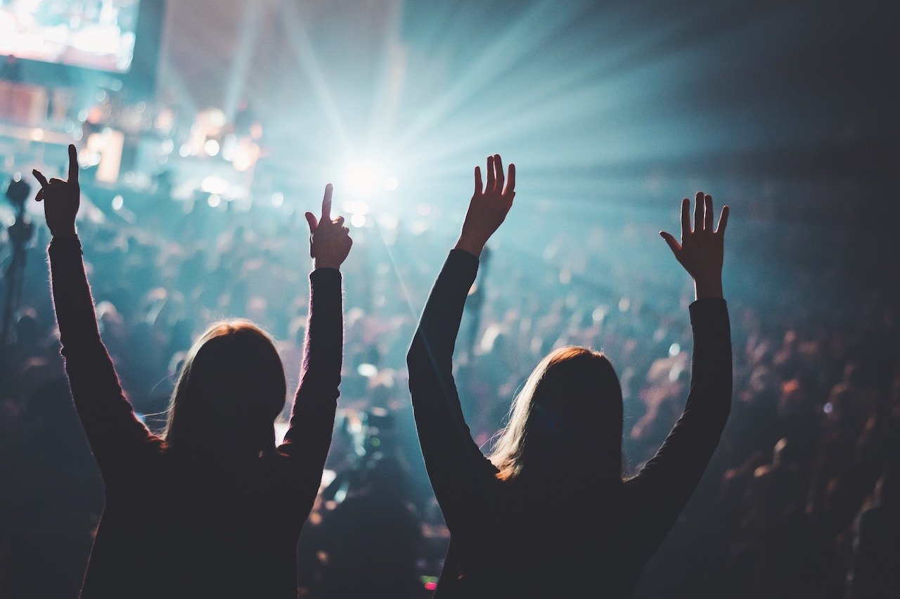 Two women worshipping at a concert
